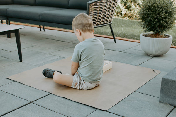 Uniklook hunter green and tan med vegan leather mat used outside as a picnic mat