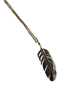 Gold feather pendant necklace on a white surface