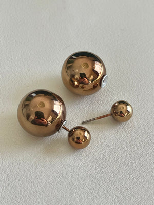 Set of gold spherical earrings on a light gray background