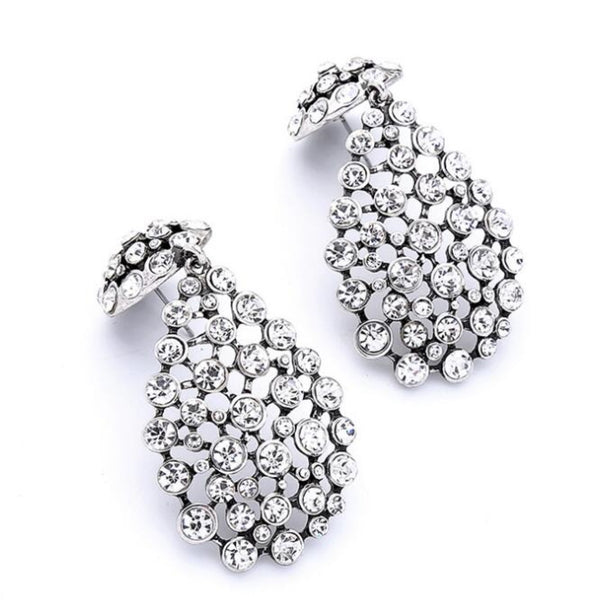 Pair of silver earrings with clear gemstones on a white background