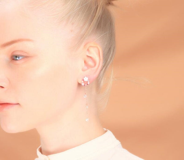 Close-up of a person wearing earrings with a soft background