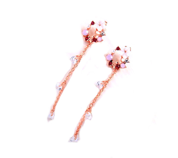Rose gold floral earrings with gemstones on a white background