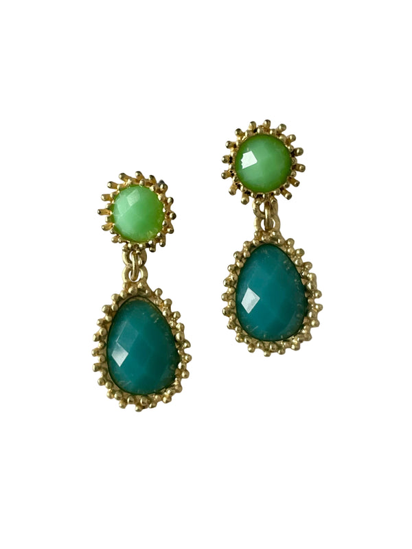 Pair of earrings with green gemstones on a light gray background