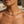 Charger l'image dans la galerie, A close-up lifestyle shot of a model wearing a delicate gold snake chain necklace with a small central clasp, set against a softly blurred background.
