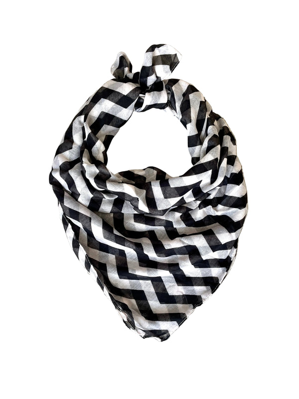 Black and white zigzag patterned scarf on a textured surface