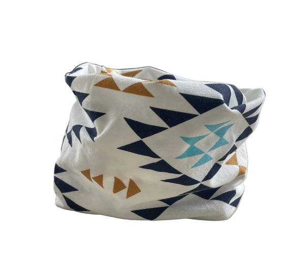 Patterned pouch attached to a chair armrest with a window and plant in the background