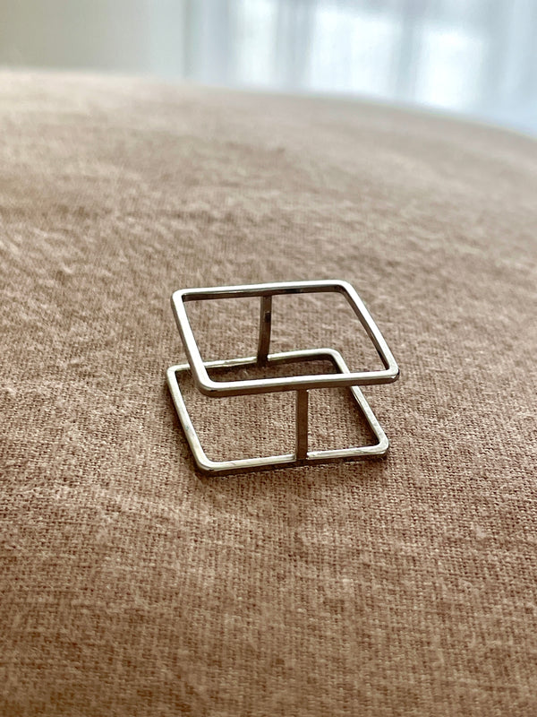 Metallic ring with geometric design on a textured surface