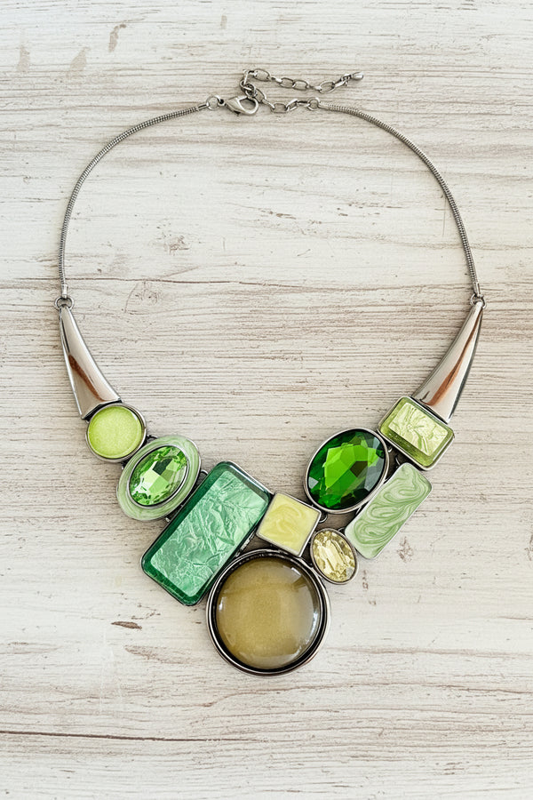Necklace with green and silver design on a dark surface