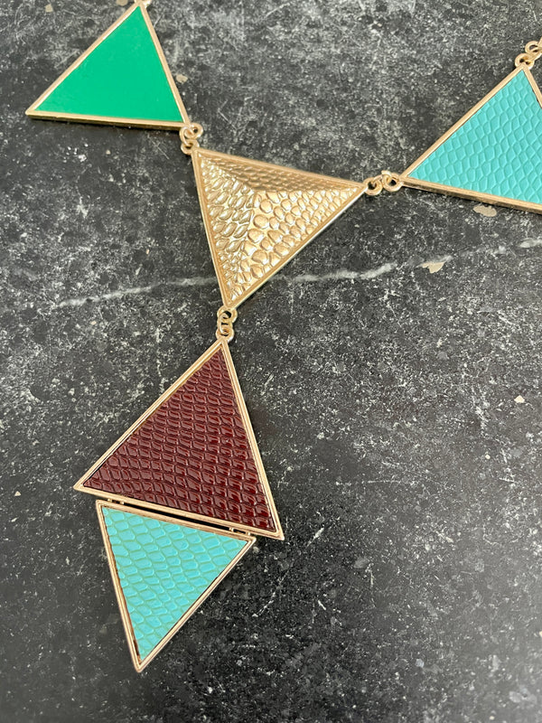 Geometric necklace with triangular pendants on a dark surface