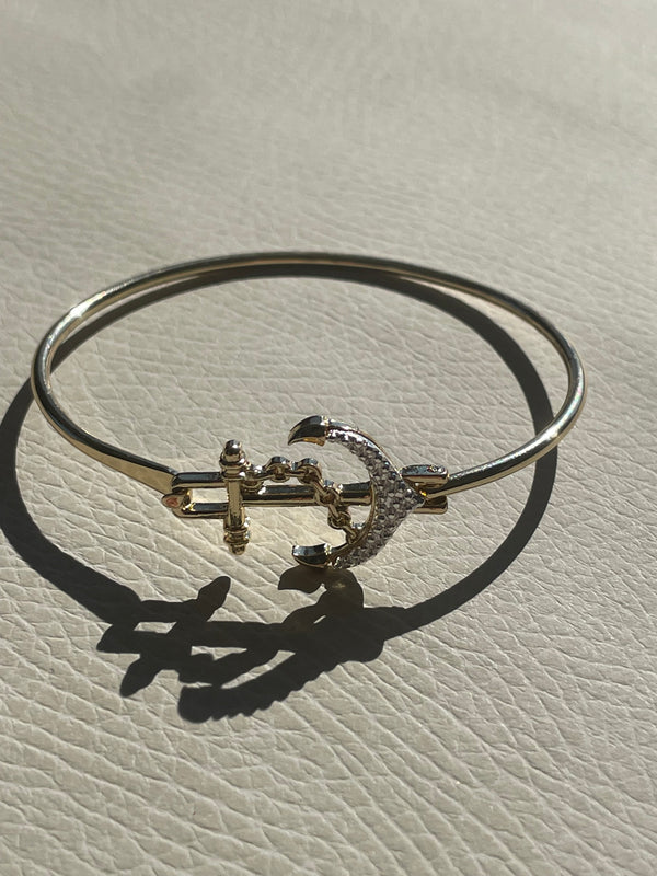 Silver bracelet with a decorative clasp on a textured beige surface