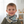 Load image into Gallery viewer, Child wearing a patterned scarf in a room with toys on shelves
