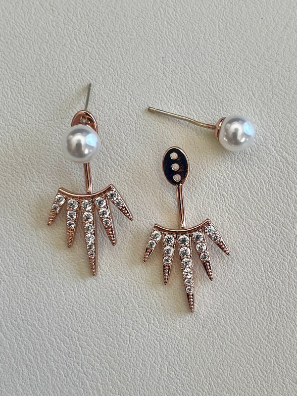 Pair of earrings with pearl and crystal details on a light gray background