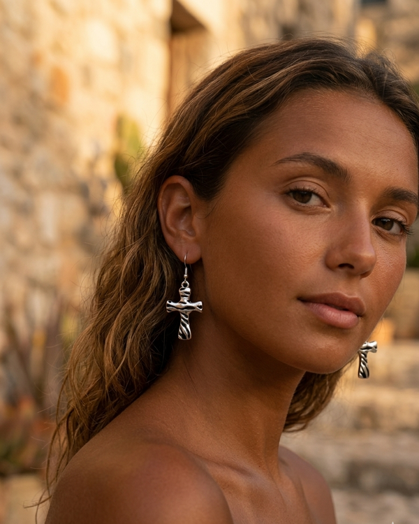 Woman wearing silver earrings with a blurred outdoor background
