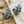 Charger l'image dans la galerie, Pair of decorative earrings on a sandy surface with shells.
