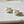 Load image into Gallery viewer, A pair of drop earrings with large, milky white marbled beads connected by small gold spacers to smaller, pale pinkish-white beads, displayed on a neutral light gray background.
