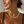 Charger l'image dans la galerie, A close-up lifestyle shot of a woman wearing a chunky gold chain necklace with interlocking oval links, paired with a black ribbed tank top against a textured white wall.
