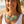 Load image into Gallery viewer, Woman wearing a white tank top and green floral necklace on a beach.
