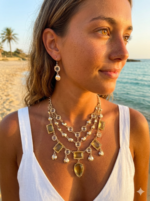 Woman wearing a layered necklace and earrings on a beach
