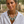 Load image into Gallery viewer, Woman wearing a white shirt and a decorative necklace with green leaves and pearls outdoors.

