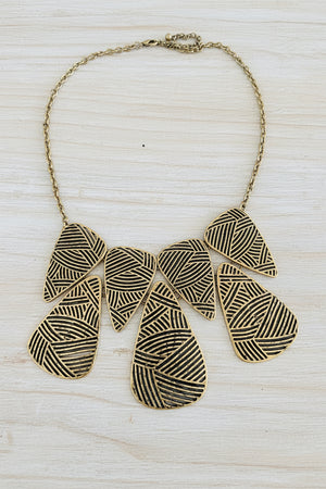 Necklace with geometric pendant on a light wood surface
