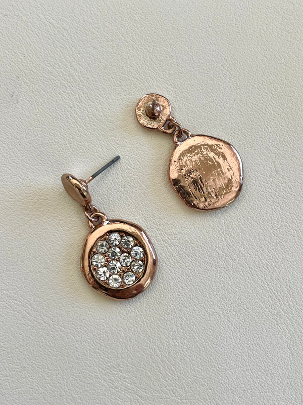Rose gold earrings with gemstones on a light gray background