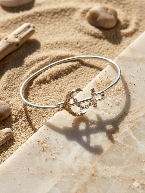 Silver bracelet with a heart and arrow design on a sandy surface