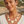 Charger l'image dans la galerie, A woman wearing a cream-colored geometric statement necklace and matching drop earrings, photographed outdoors against a blurred coastal background.
