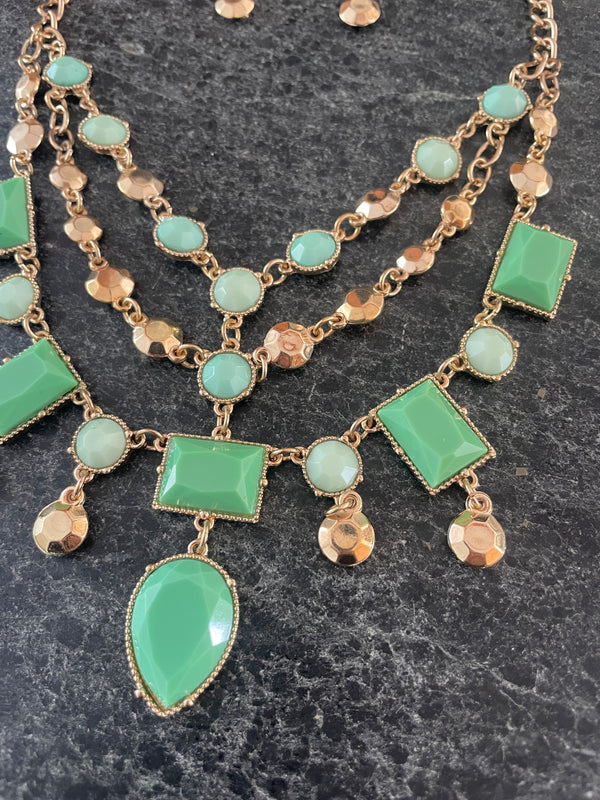Necklace with green gemstones on a dark textured background