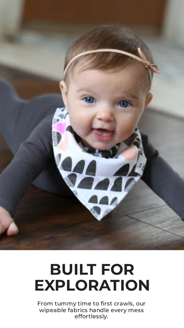 Baby wearing a bib with text 'Built for Exploration' at the bottom