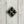 Load image into Gallery viewer, A vintage-style diamond-shaped brooch featuring four inset black faceted gemstones divided by a silver cross, set within a textured silver border on a white background.
