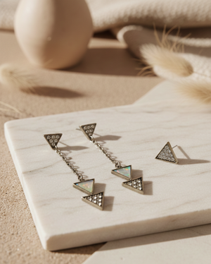Geometric earrings on a marble surface with a neutral background