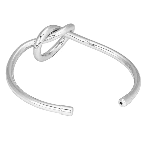 Silver bangle with a unique design on a light gray background