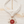 Load image into Gallery viewer, Necklace with a red and white wheel pendant on a light wooden surface
