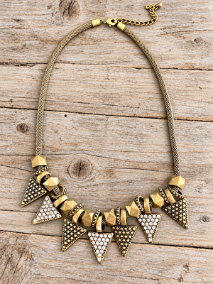 Golden Edge Statement Necklace – Crystal Triangle Bib Necklace lay flat on a wood