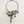 Load image into Gallery viewer, A silver-toned statement necklace featuring a snake, leaf, owl, dragonfly, and teardrop charms, displayed on a light wood background.
