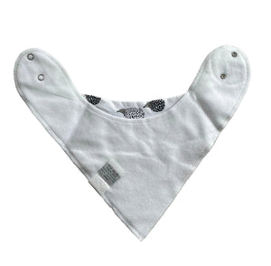 White baby bib with black patterns on a beige surface
