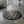Load image into Gallery viewer, Round gray quilted mat in a modern room with large windows and a plant.
