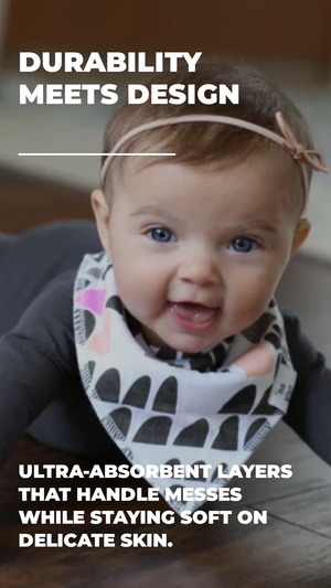Baby wearing a bib with text about durability and absorbent layers