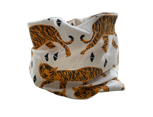 Fabric with tiger pattern draped over a chair in a room with a window and plant.