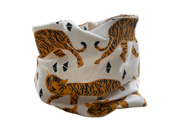 Fabric with tiger pattern draped over a chair in a room with a window and plant.
