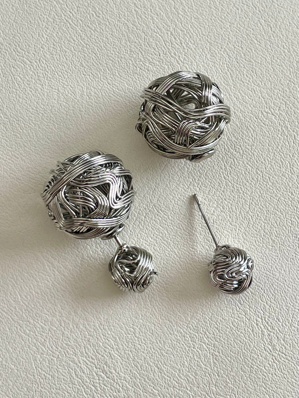 Pair of silver ball earrings on a light gray background