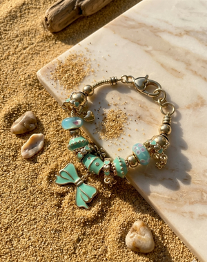 Bracelet with turquoise and gold beads on a sandy surface