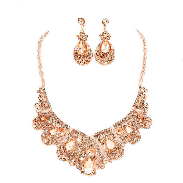 Rose gold necklace and earrings set on a white background