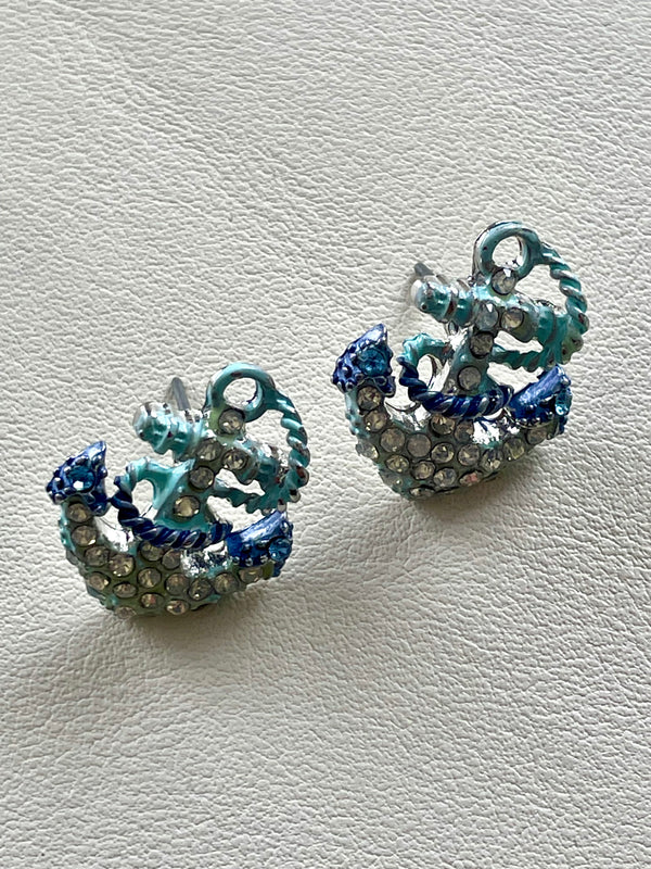 Pair of decorative earrings with blue and silver design on a light gray background