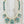 Load image into Gallery viewer, Necklace with turquoise leaves and pearls on a dark surface
