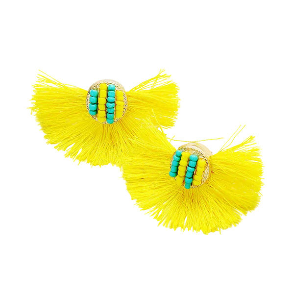 Yellow tassel earrings with turquoise beads on a light gray background