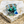 Load image into Gallery viewer, Butterfly-shaped brooch with blue and silver details on a textured stone surface
