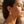 Charger l'image dans la galerie, Woman wearing earrings with a blurred beach background
