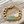Load image into Gallery viewer, Gold chain bracelet with a green gemstone clasp on a wooden surface
