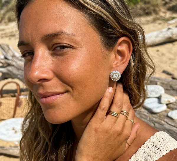 Woman wearing a diamond earring on a beach
